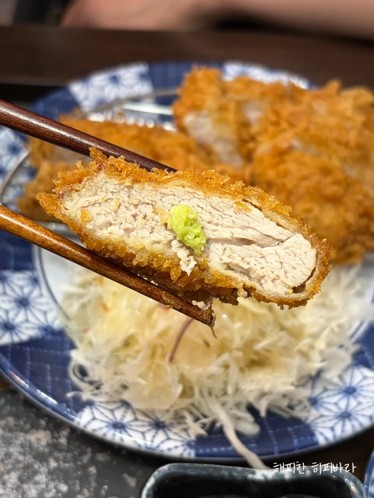 A piece of hire katsu topped with wasabi