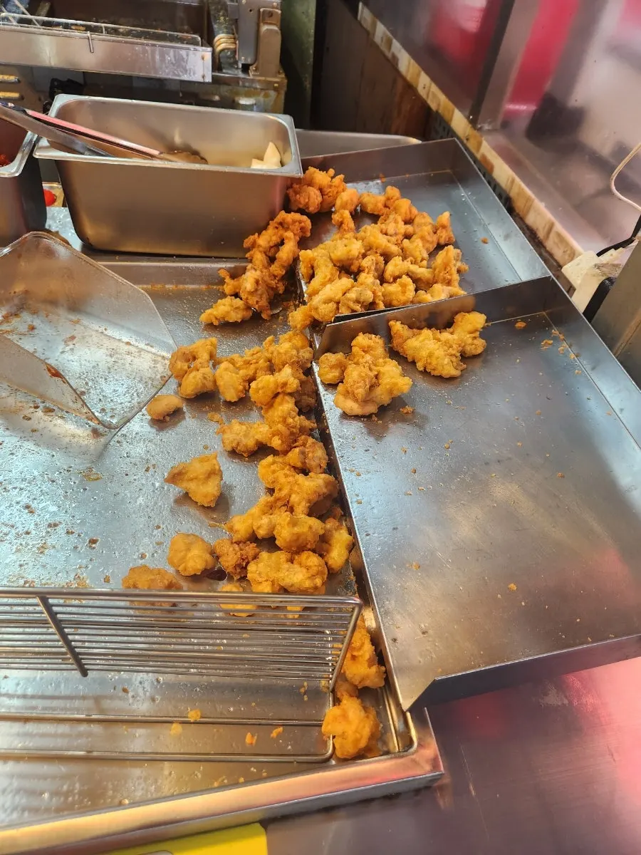 Dakgangjeong being tossed with sauce right after ordering