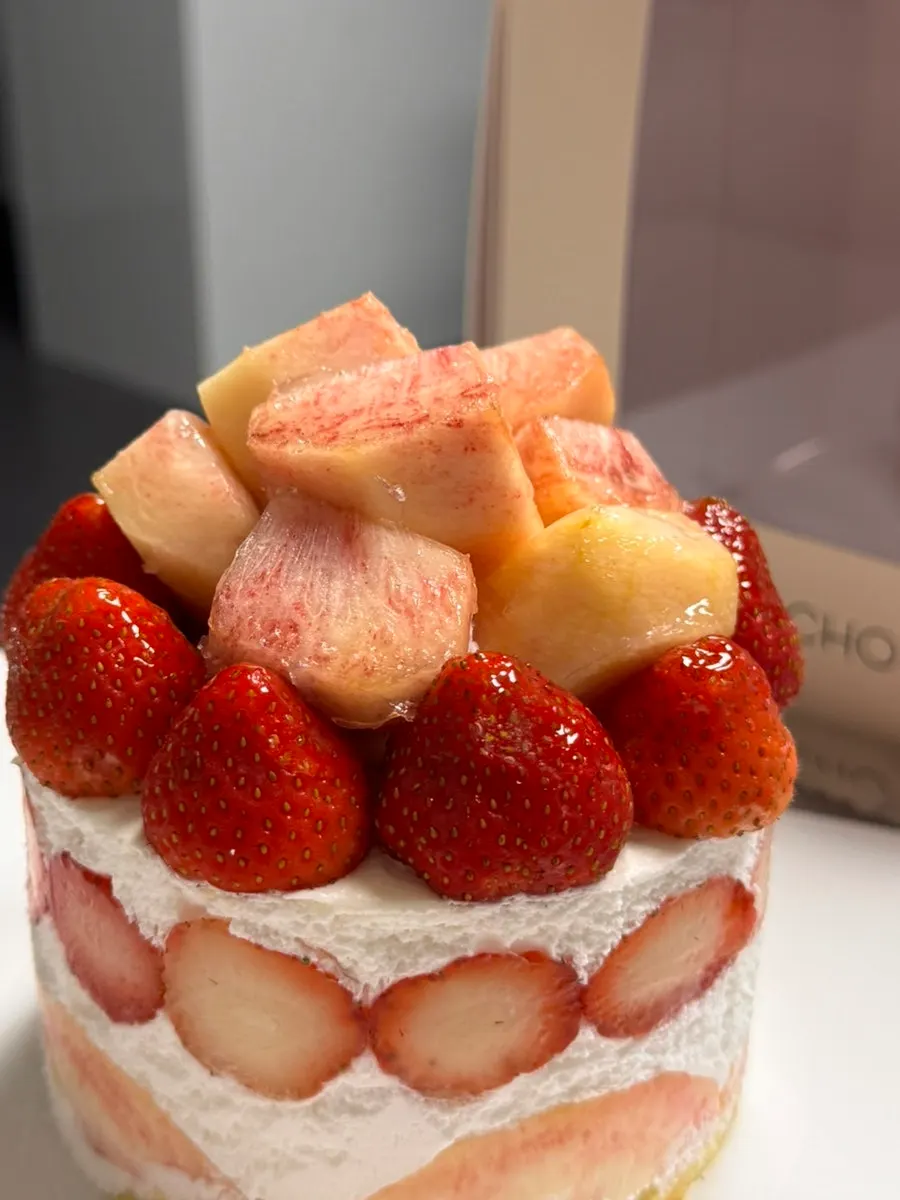 Fruit decoration on the peach berry cake as the box opens