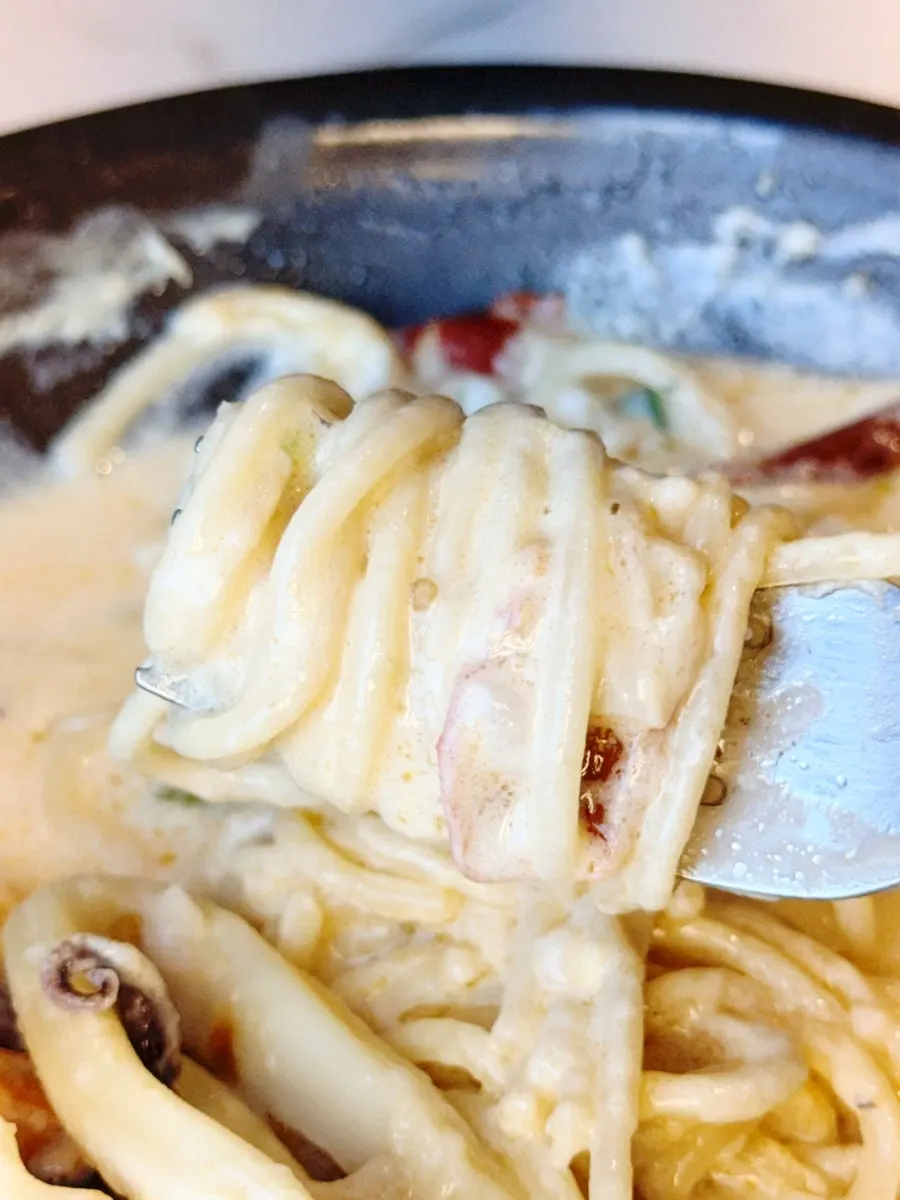A spoonful of risotto soaked in sauce