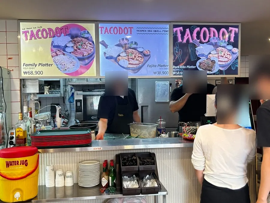 Taco Dot self-serve bar with hot sauce and cutlery