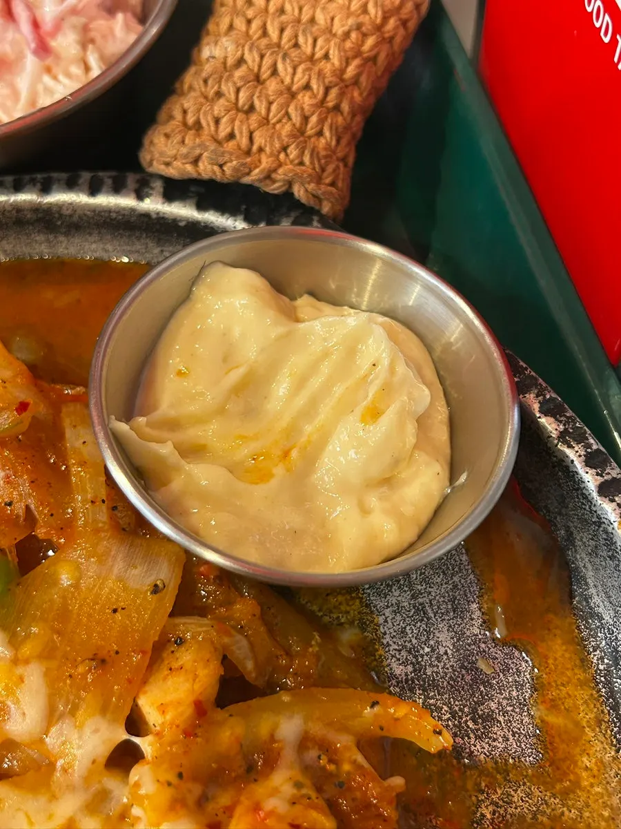 Hot chicken fajita wrapped in tortilla and dipped in sauce
