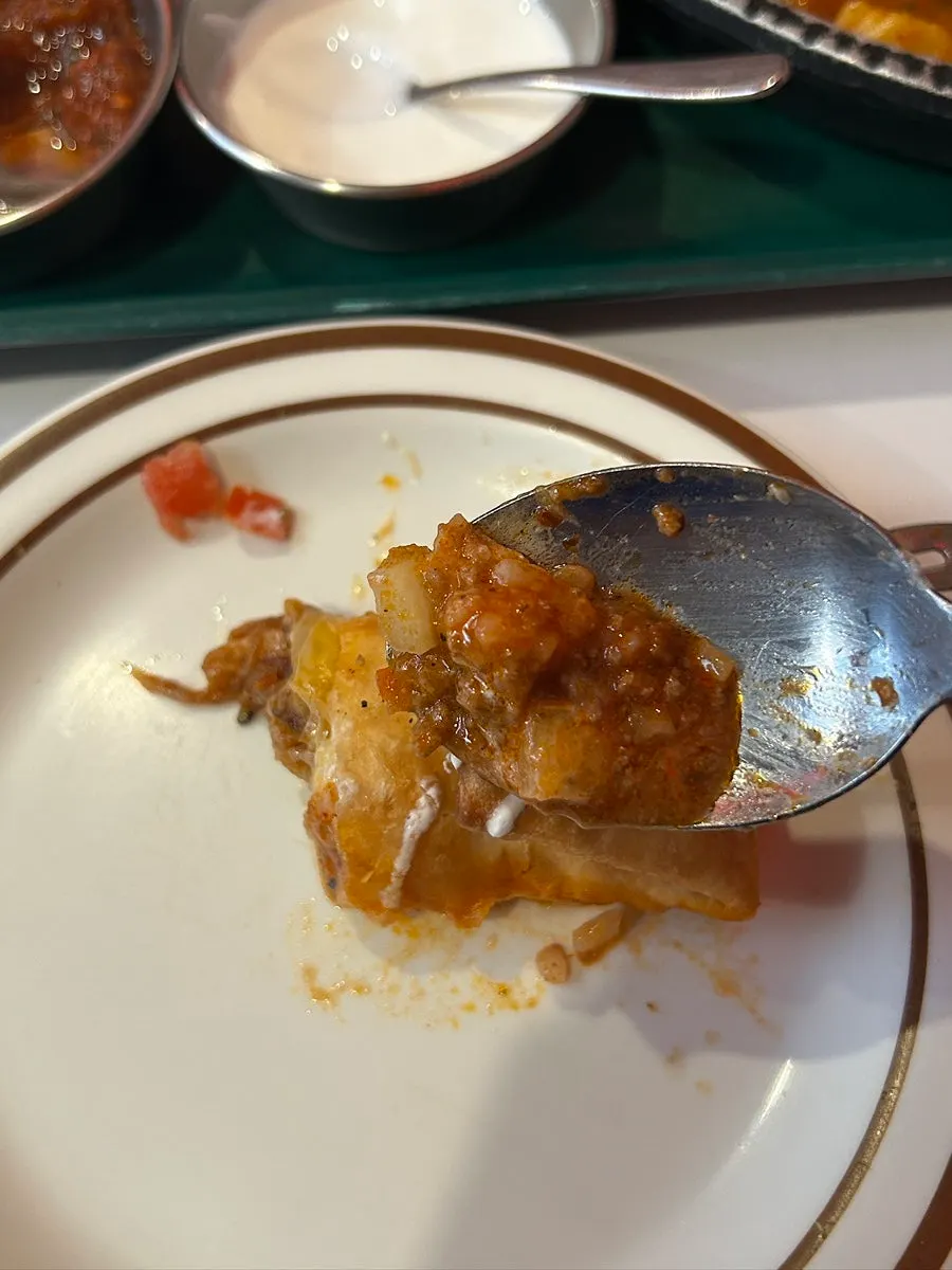 A piece of chimichanga dipped in sauce