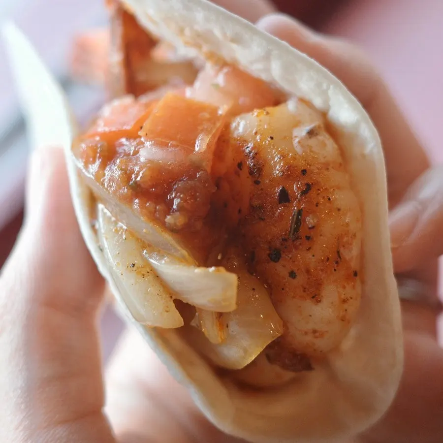 Tortilla topped with shrimp, salsa and grilled onion
