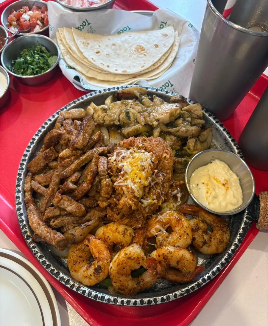 Fajita platter with meat, shrimp, and grilled vegetables