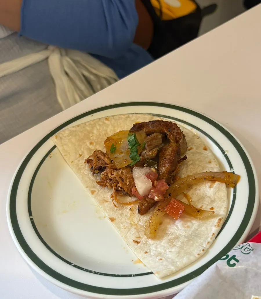 Fajita wrap being eaten with sauce