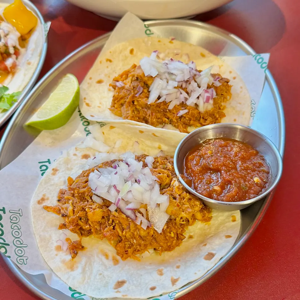 Carnitas taco served with lime and salsa sauce