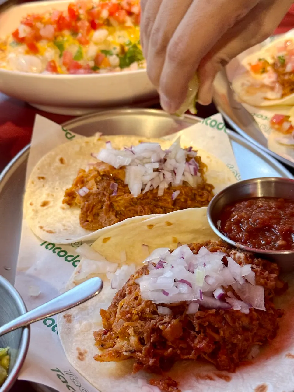 Carnitas taco piled high with raw onion