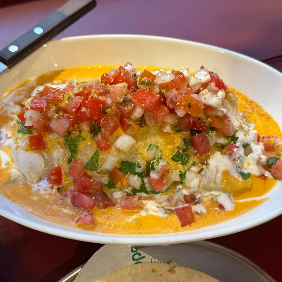 Jerk chicken enchilada covered in orange paprika sauce