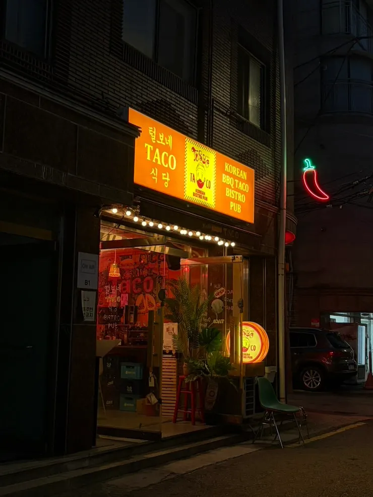 골목 안쪽 붉은 조명의 털보네 타코 식당 외관 간판