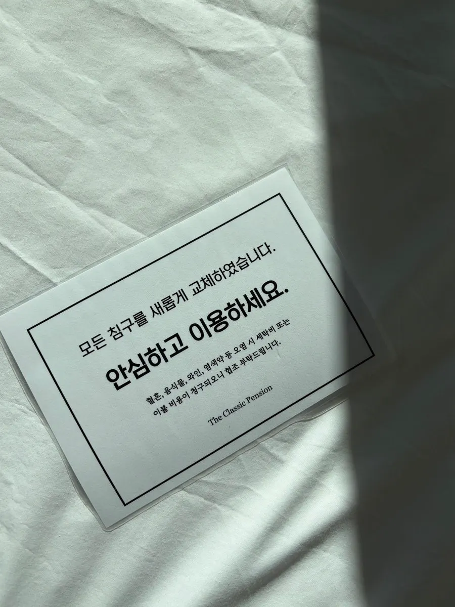 큰 창 옆에 놓인 객실 침대와 침구