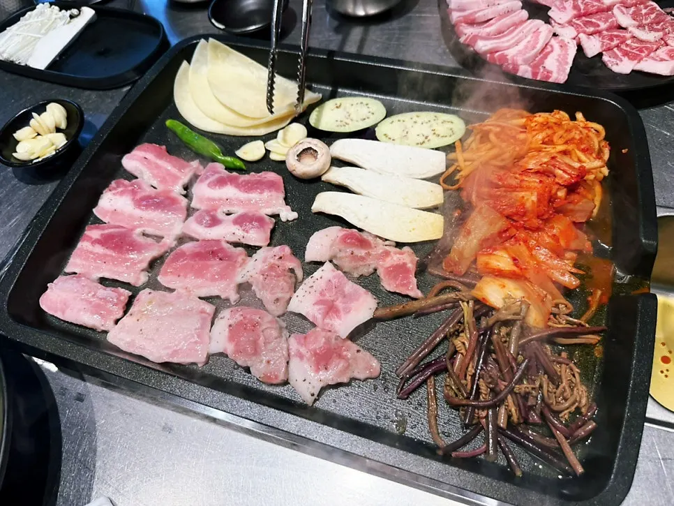 Full table setting including kimchi stew alongside the meat