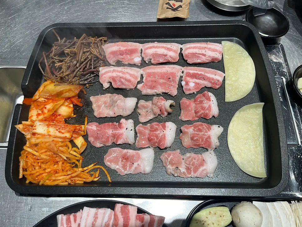 Korean pork belly browning to a golden crisp on the grill