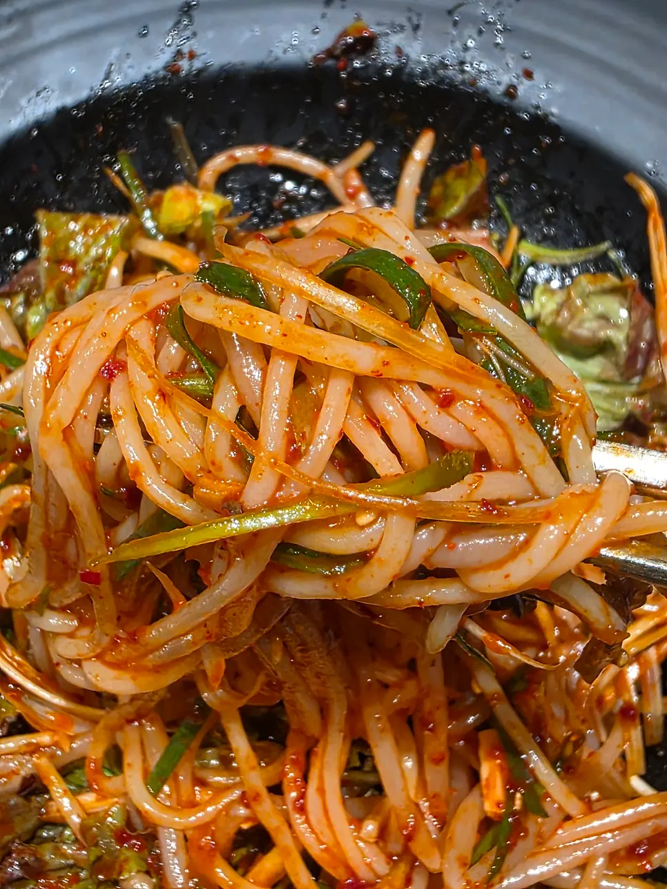 Lifting a bite of the jjolmyeon noodles