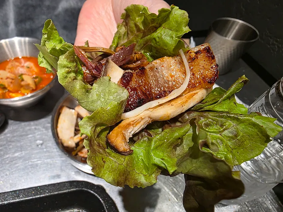 A wrap of samgyeopsal on pickled radish
