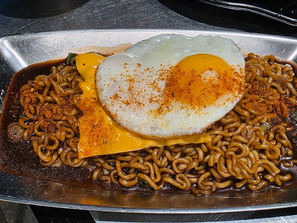 Jjagyechi topped with cheese and soft-boiled egg