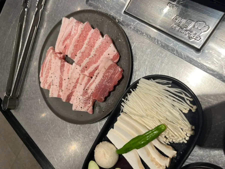 굵은 소금과 후추가 뿌려진 두툼한 생삼겹살