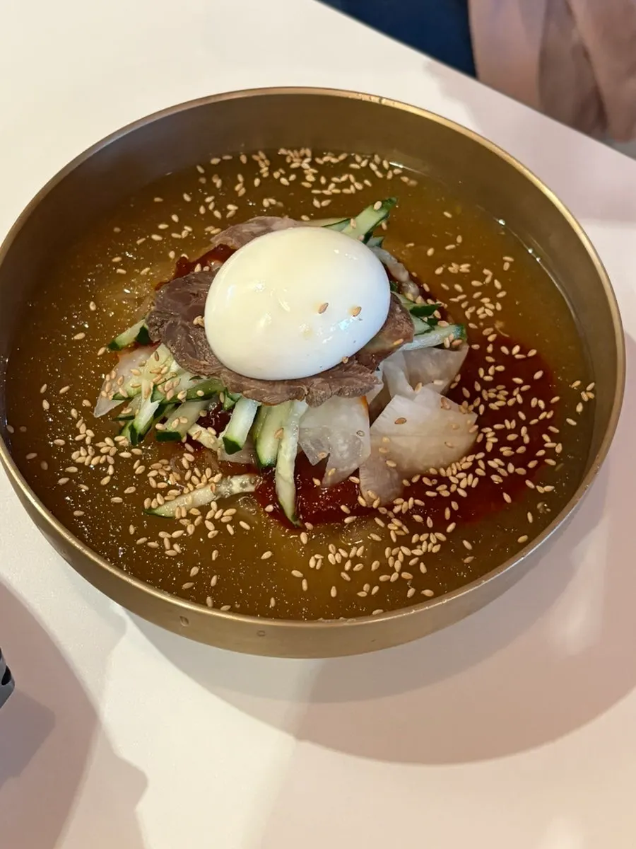 Hamheung mul bibim naengmyeon served in a brass bowl