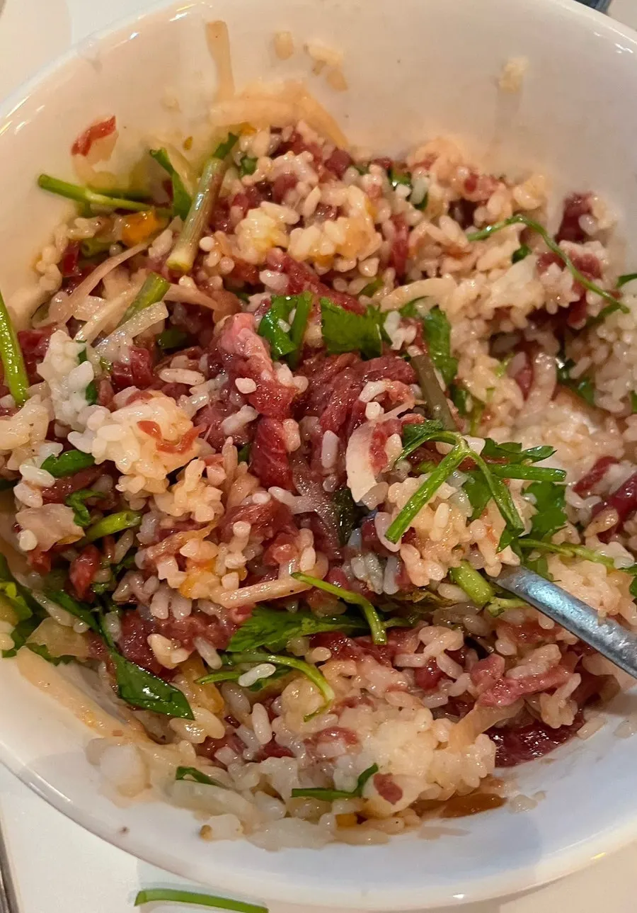 Yukhoe bibimbap topped with minari and special soy sauce dressing