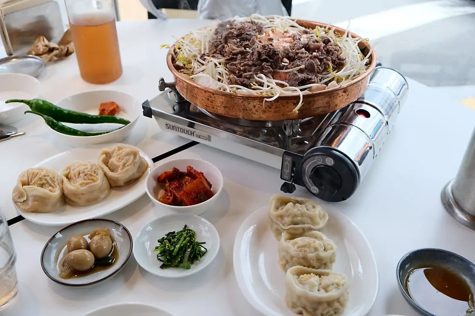 Beef bulgogi and bean sprouts cooking in the broth