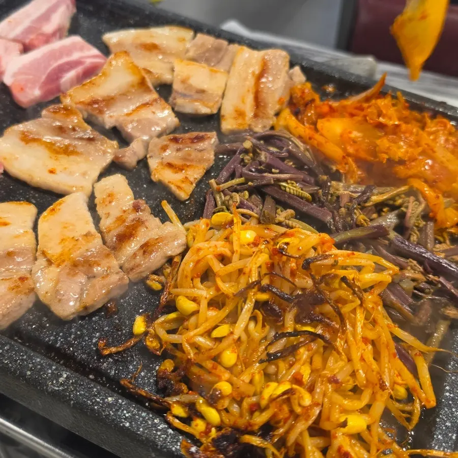 Grill topped with kimchi, bracken fern and bean sprouts