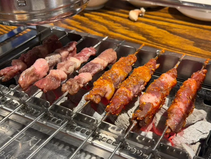 Lamb skewers placed on the auto-rotating charcoal frame