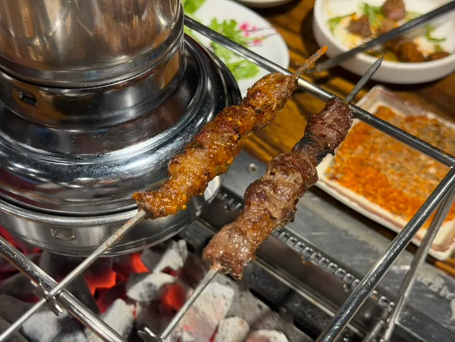 Fully cooked lamb skewers moved up top to keep warm