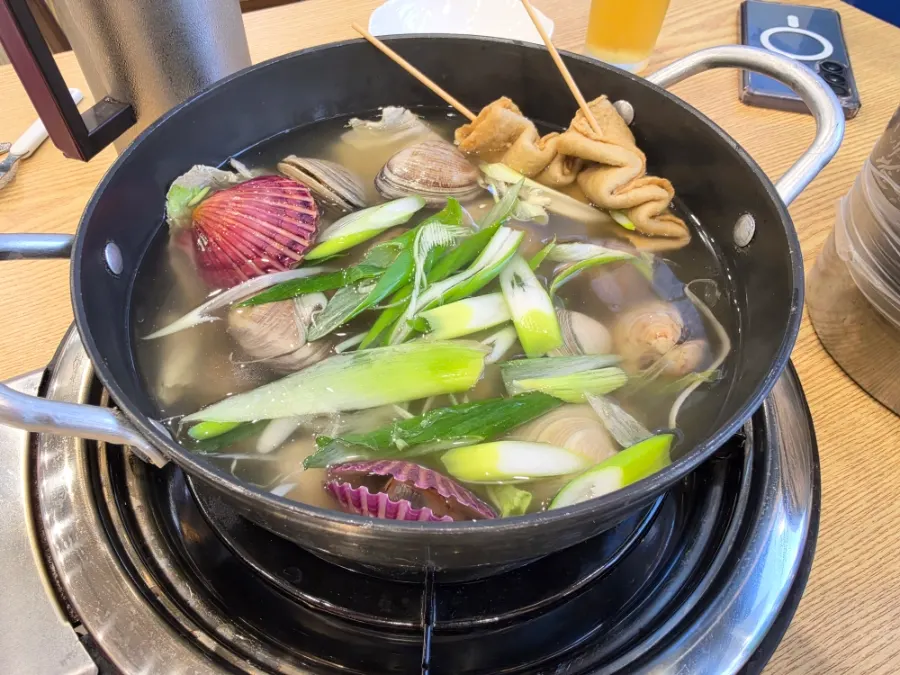 Pot of clam soup with side dishes