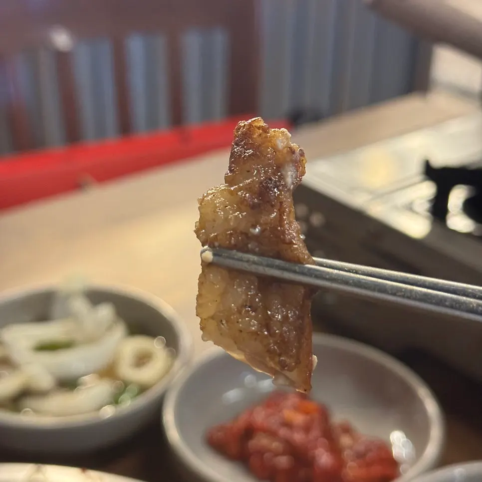 A piece of beef gopchang picked up with chopsticks