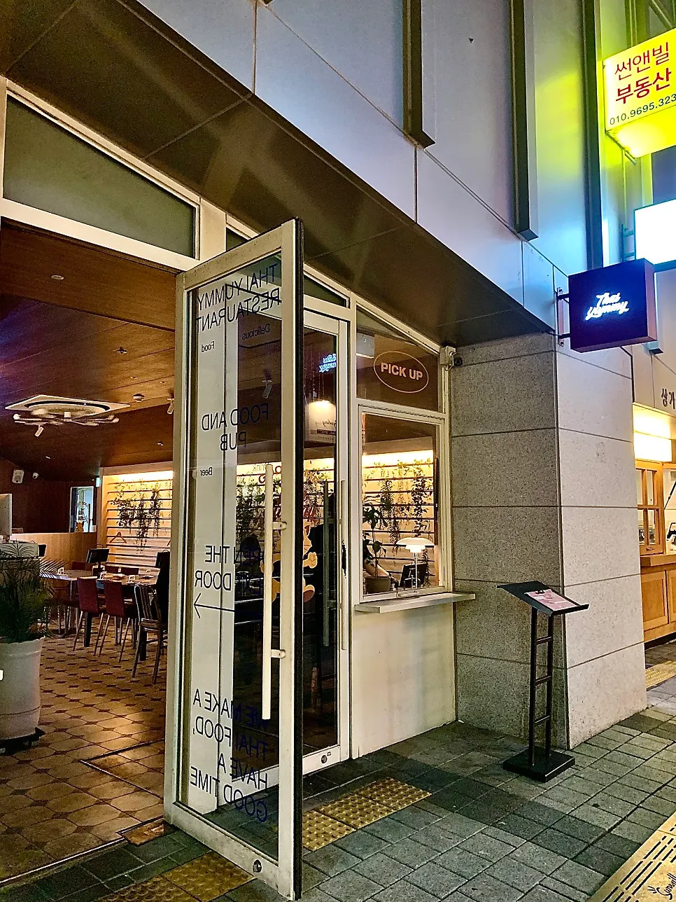 Glass door with the Thai Yami logo and cat character