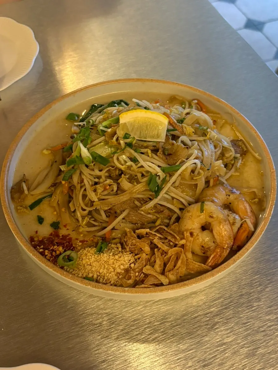 Dua piring makanan Thailand dengan pelengkap lemon