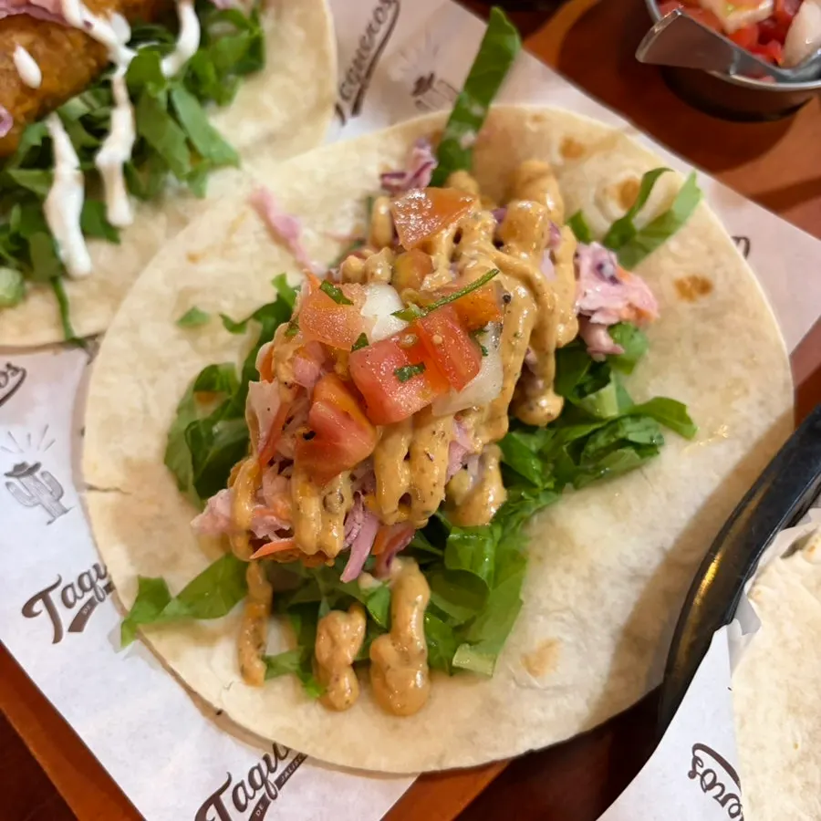 Two tacos with fried chicken and fried fish
