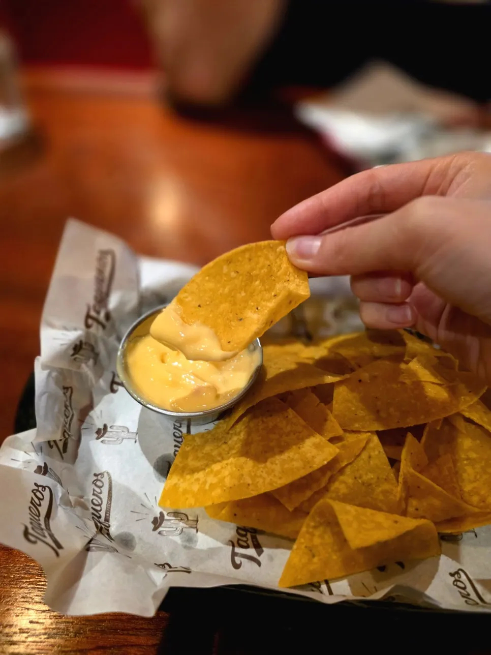 Dipping a nacho into cheese sauce