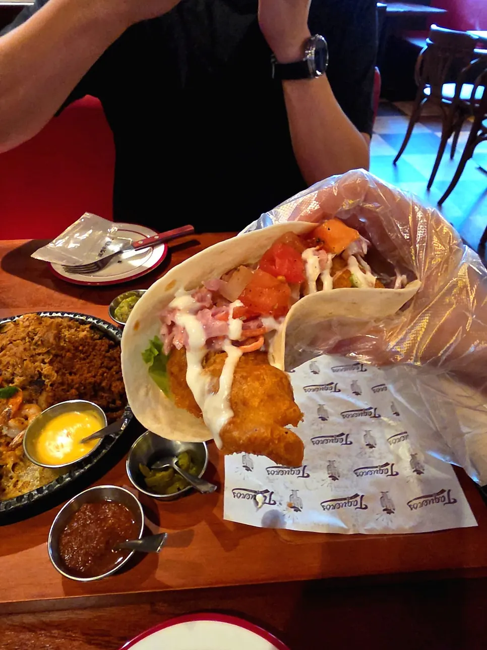Taco folded in half with disposable gloves on