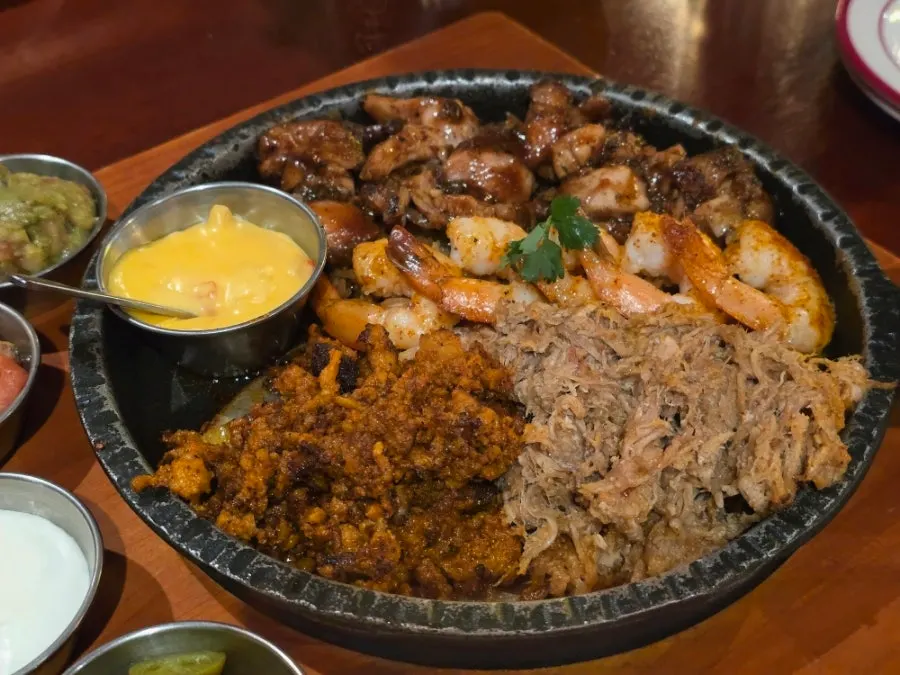 Fajita and tacos plated together on the table
