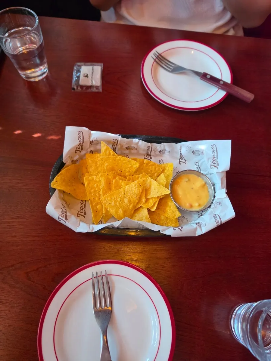 Dipping a nacho into cheese sauce