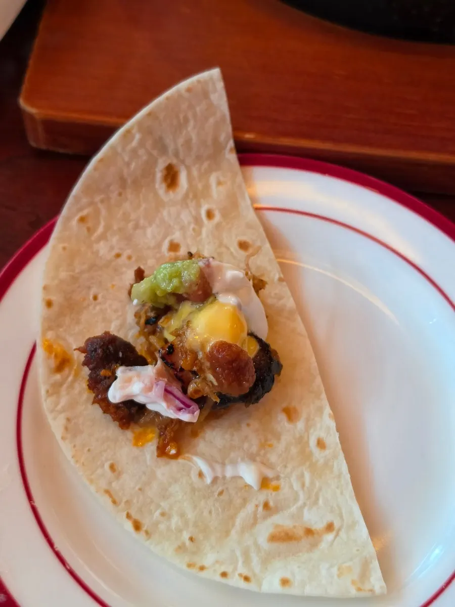 Fajita with meat and sauce piled onto a tortilla