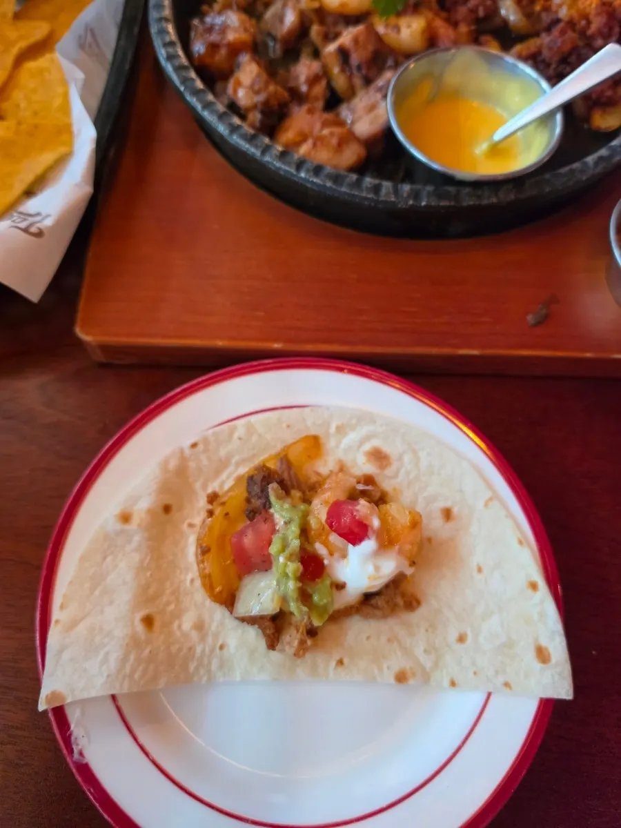 A tortilla wrapped up with plenty of sauce