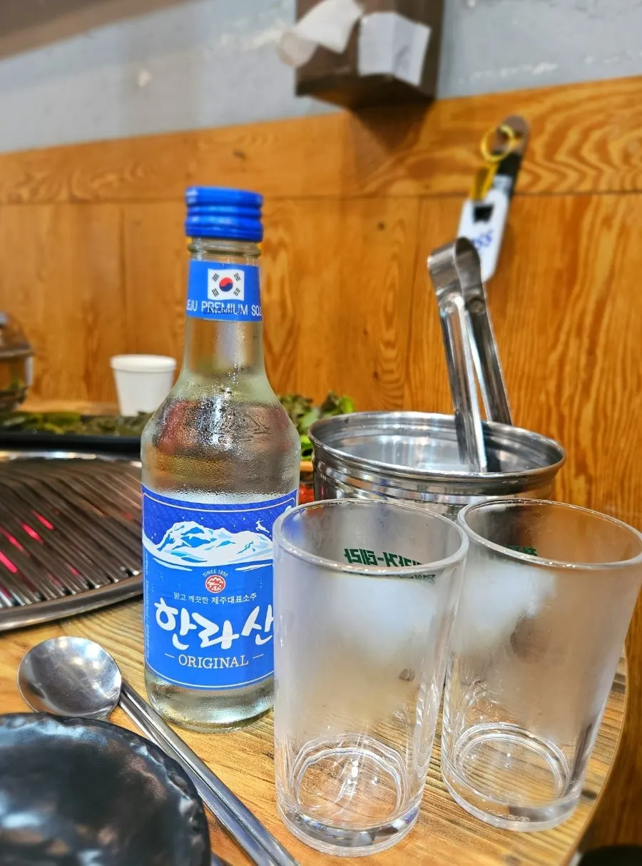 Jeju pork grilling over a charcoal fire