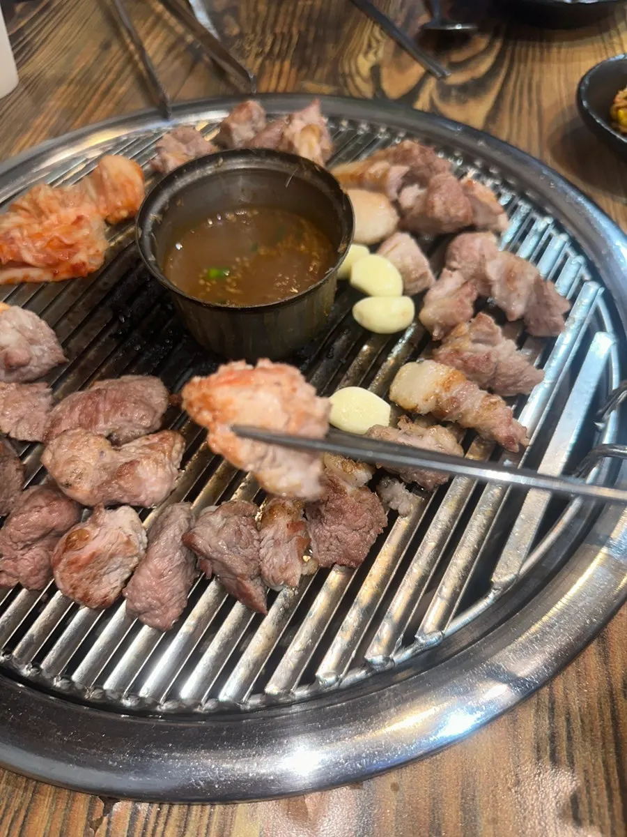 Jeju pork neck grilled over charcoal and moved to the tabletop grill