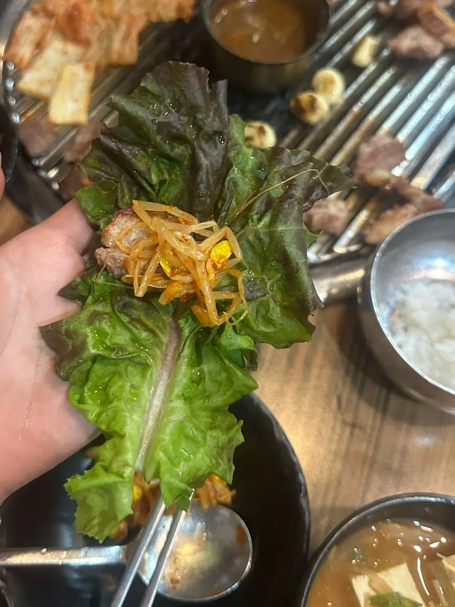 A piece of pork neck topped with perilla leaf pickles