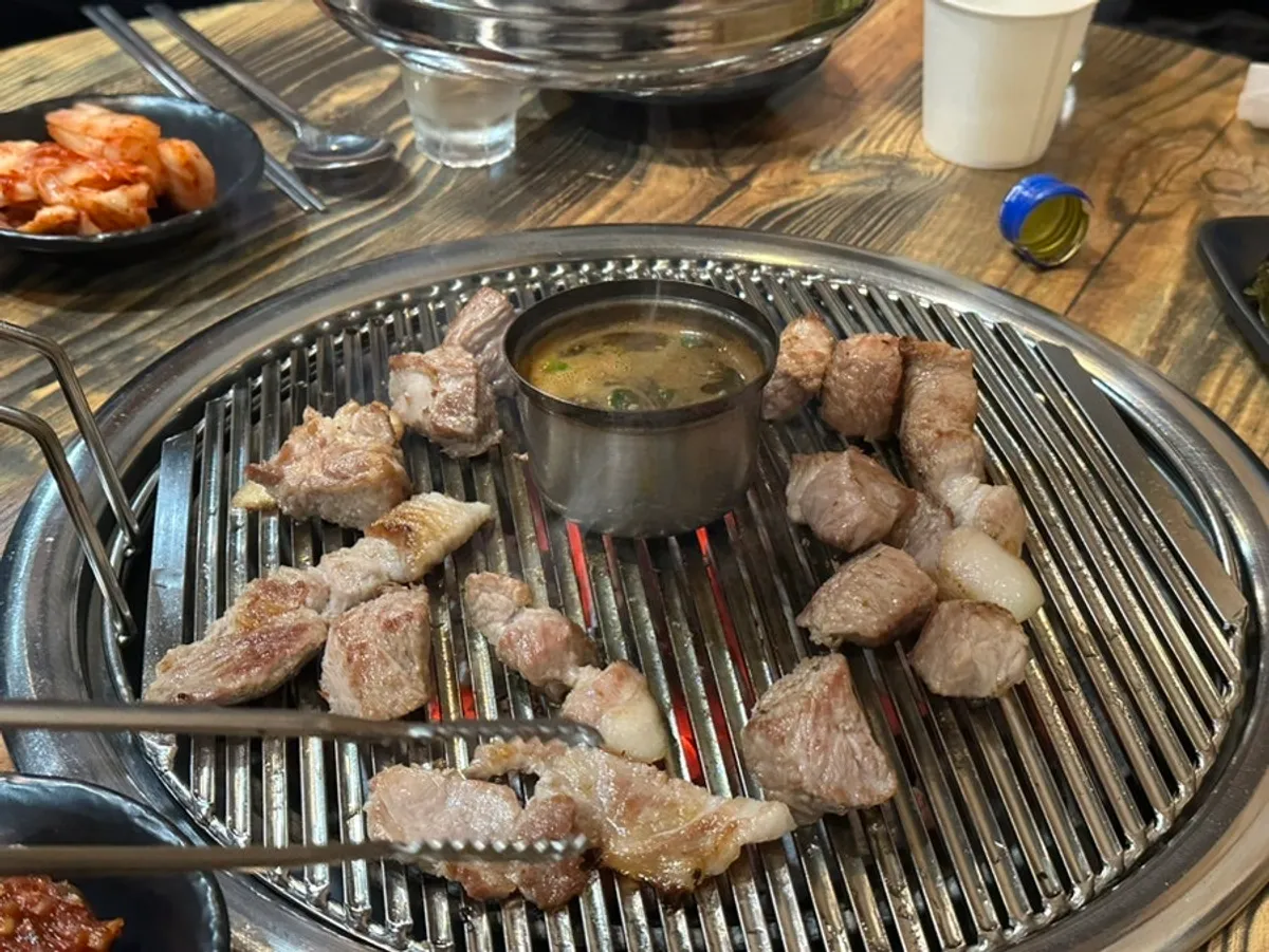 Thick cuts of Jeju pork finishing on the charcoal grill