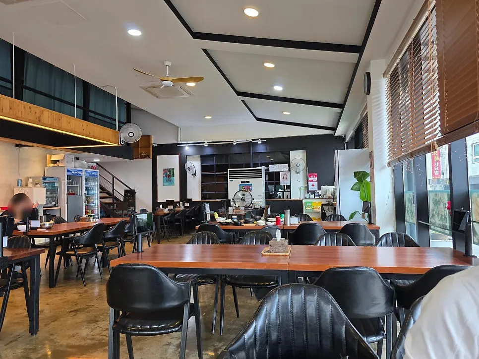 Wood-toned dining hall interior lit by large windows