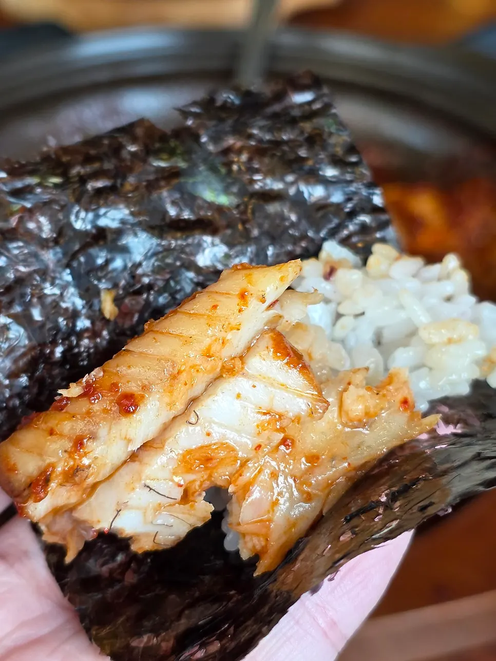A spoonful of rice topped with picked cutlassfish flesh