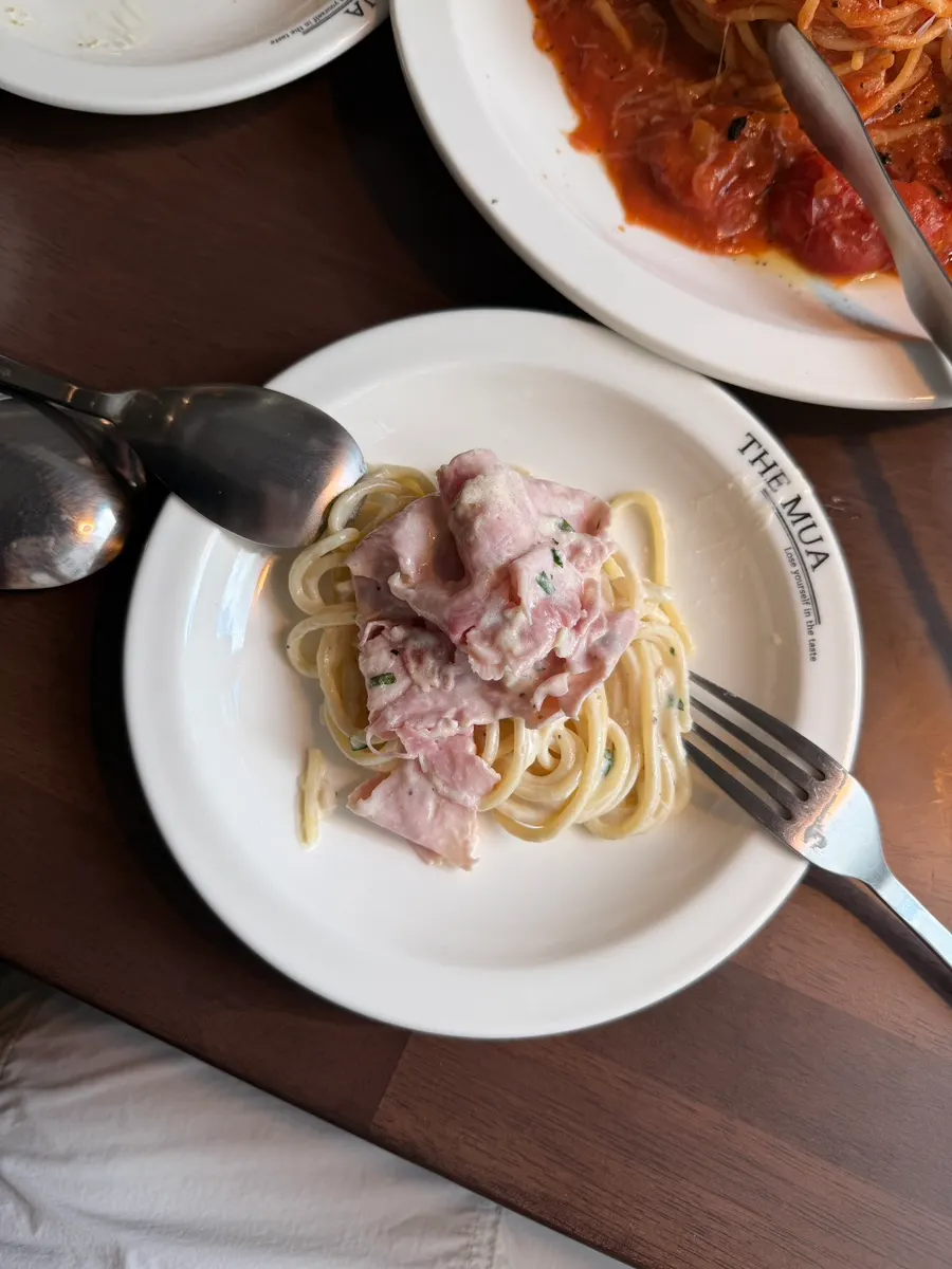 Fork lifting noodles from the jambon cream pasta