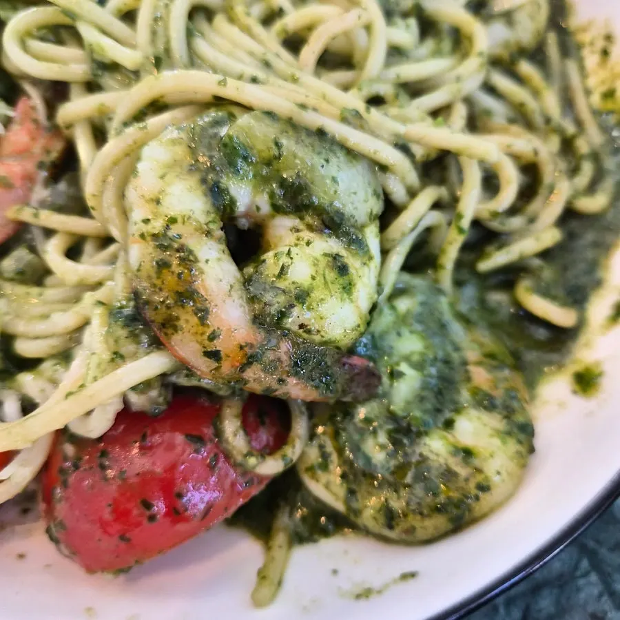 Basil pesto pasta topped with plump shrimp