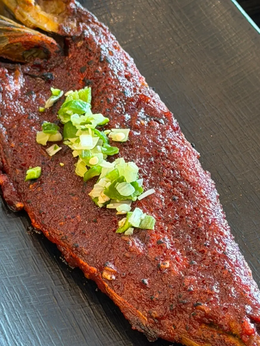 Close-up of grilled mackerel topped with sauce