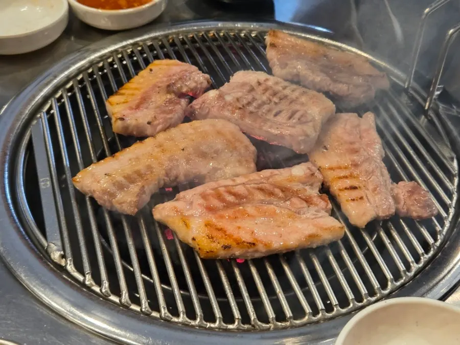 Pork belly being pre-seared over charcoal