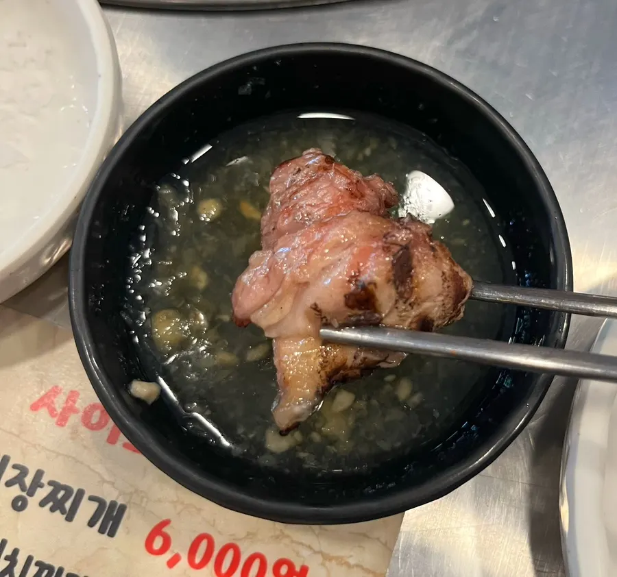Piece of pork neck dipped in sauce