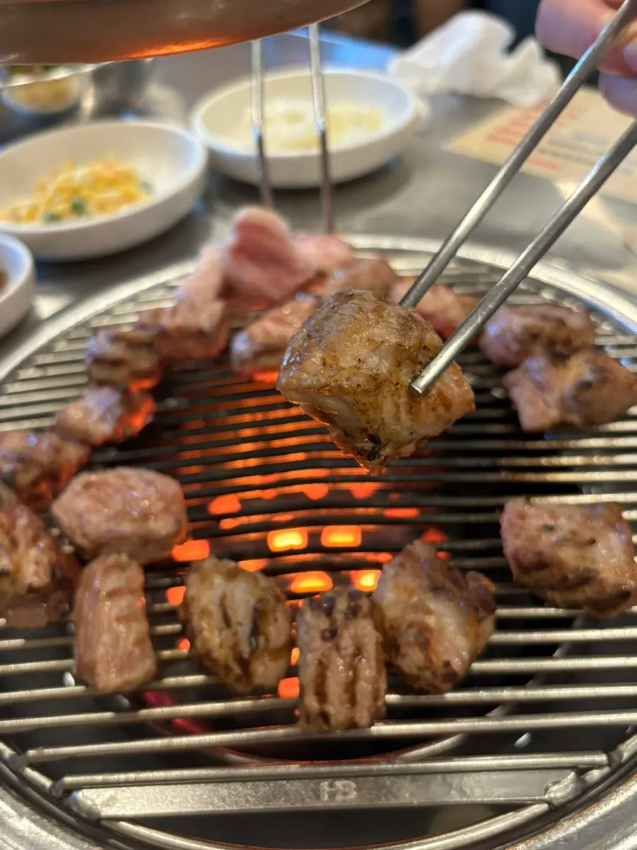 Pre-grilled pork neck on the charcoal fire